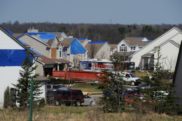 Blue tarps cover several rooftops Monday as crews work to salvage and clean up tornado-damaged homes in the Huron Farms subdivision in Dexter. Melanie Maxwell I AnnArbor.com